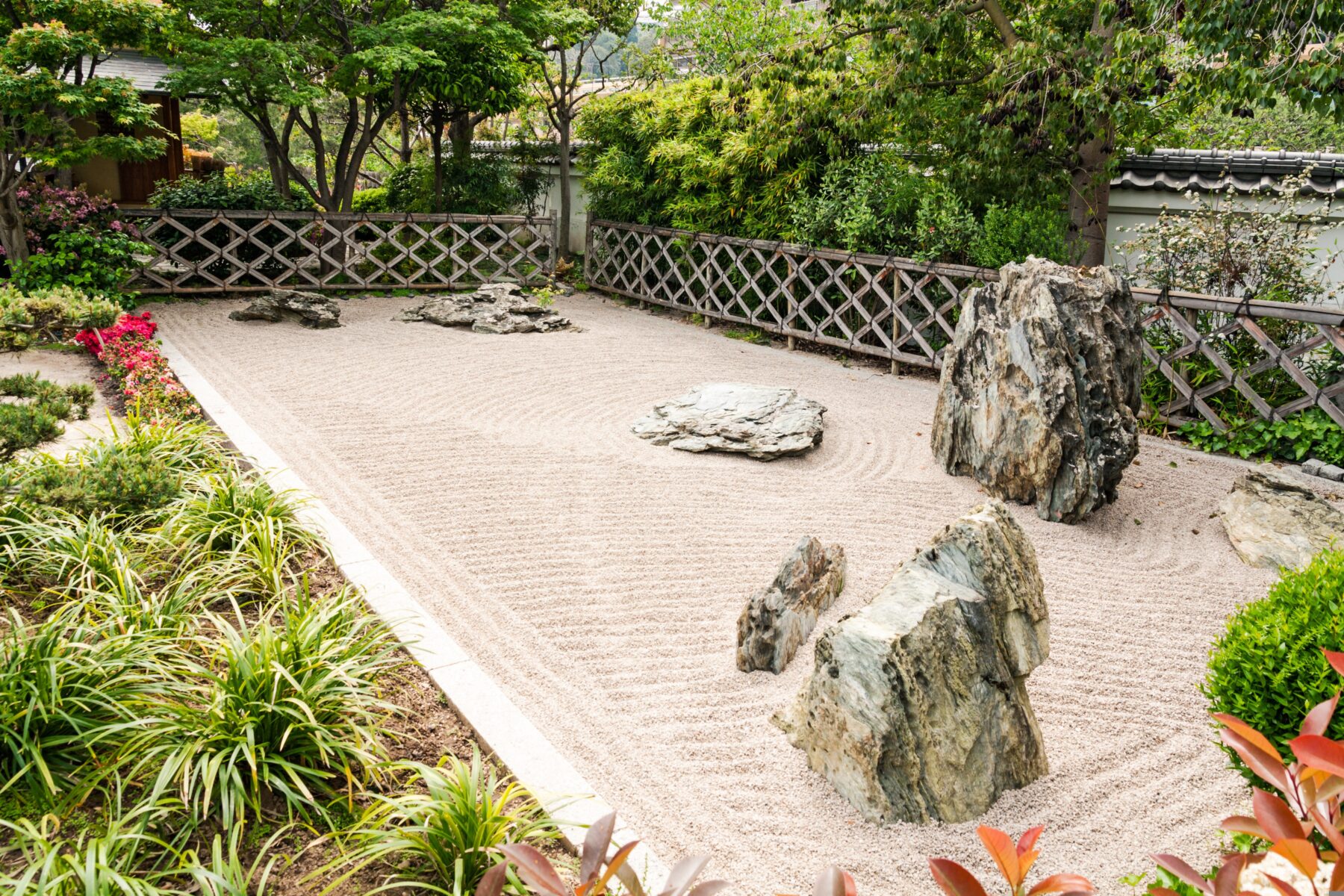 White playground sand and decorative gravel offer a minimalist yet powerful way to reimagine outdoor spaces beyond traditional landscaping. These materials are utilized for much more than just play areas or driveways. When combined with intent, they become design elements that shape how a garden feels, how it’s used, and how it evolves with the seasons. 
