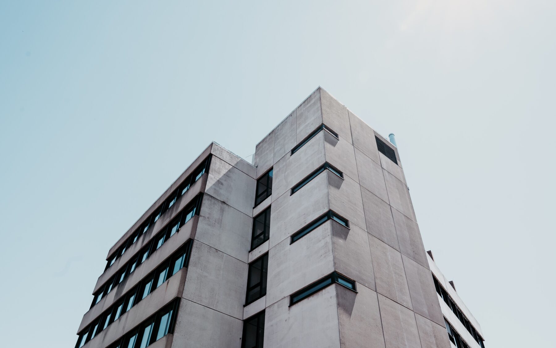 Detailed view of a concrete skyscraper facade highlighting textured formwork and structural elements, used to illustrate high-strength concrete benefits for taller, safer buildings in Cessford Construction service areas.